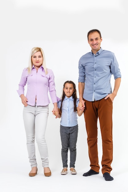 Familia joven feliz con niño bonito posando sobre fondo blanco