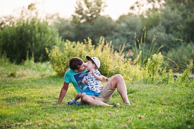 Familia joven feliz: padre con hijo en la naturaleza divirtiéndose.