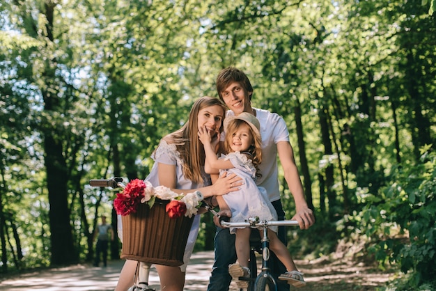 Familia joven feliz pasar tiempo juntos afuera. Padre madre y su hijo en el parque verde en un picnic.