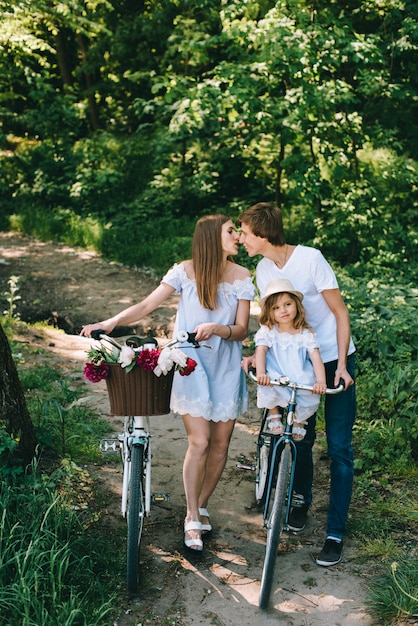 Familia joven feliz pasar tiempo juntos afuera. Padre madre y su hijo en el parque verde en un picnic.