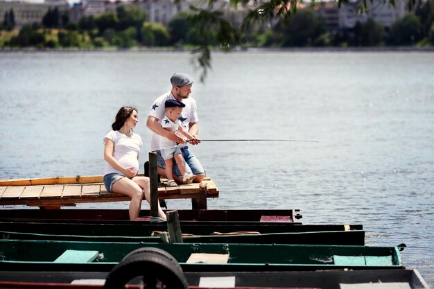 Familia joven feliz pescando en el lago