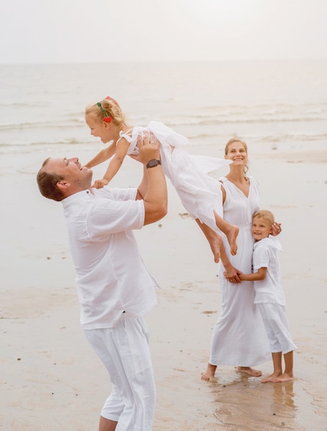 Familia joven feliz en la puesta de sol en la playa.