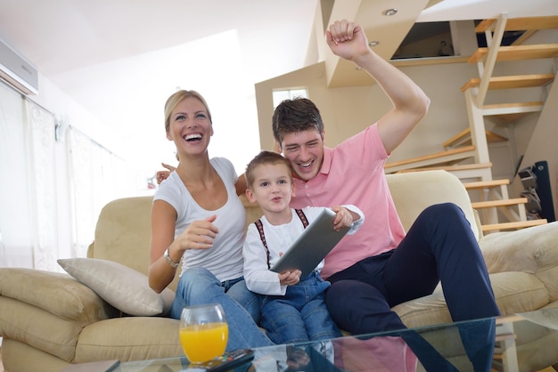 familia joven feliz que usa una tableta en un hogar moderno para jugar juegos y educación