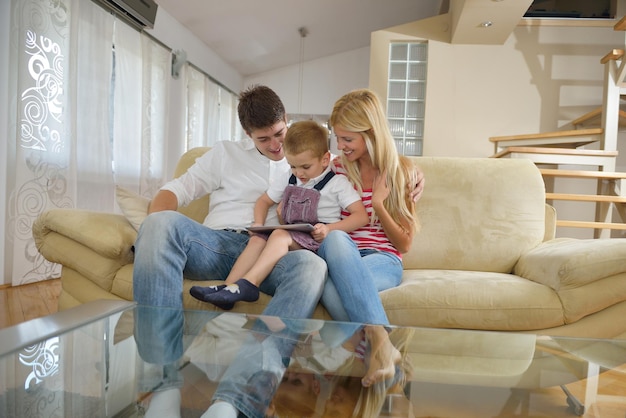 familia joven feliz que usa una tableta en un hogar moderno para jugar juegos y educación