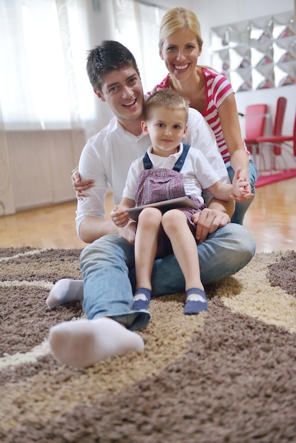 familia joven feliz que usa una tableta en un hogar moderno para jugar juegos y educación