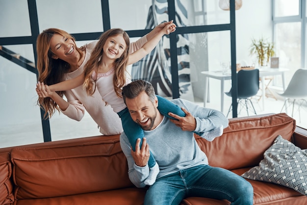 Familia joven feliz uniendo juntos en casa