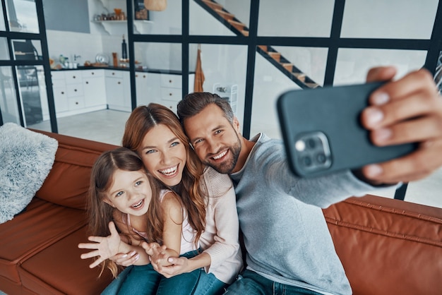 Familia joven feliz uniendo juntos en casa