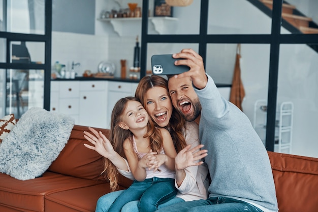 Familia joven feliz uniendo juntos en casa