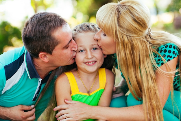 Familia joven y hermosa en el parque. Madre, padre e hija