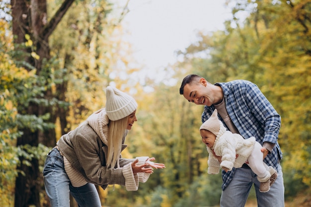 Familia joven con hija pequeña en el parque otoño