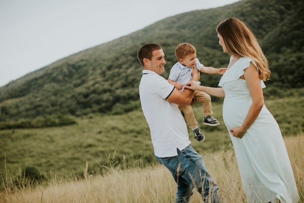 Foto familia joven con lindo niño divirtiéndose al aire libre en el campo de verano