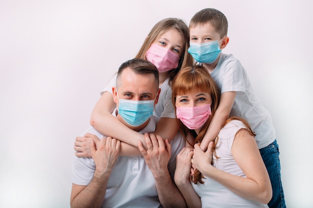 Familia joven en máscaras médicas durante la cuarentena domiciliaria.