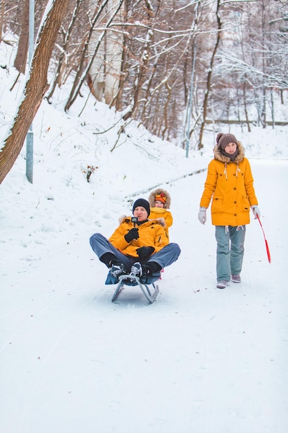 Familia joven navegando juntos al aire libre en el día de invierno nevado