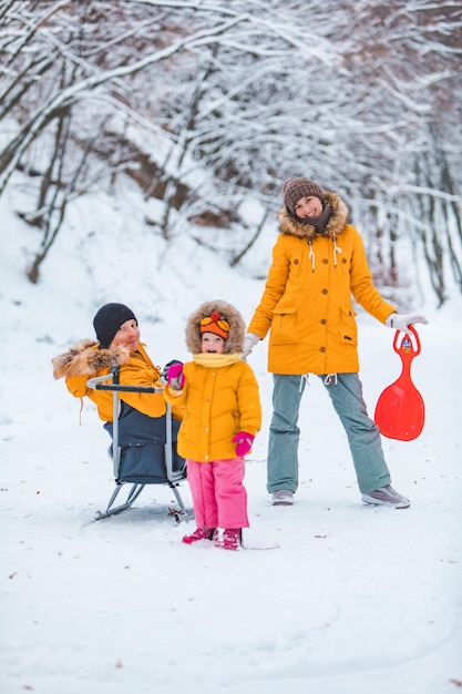 Familia joven navegando juntos al aire libre en el día de invierno nevado