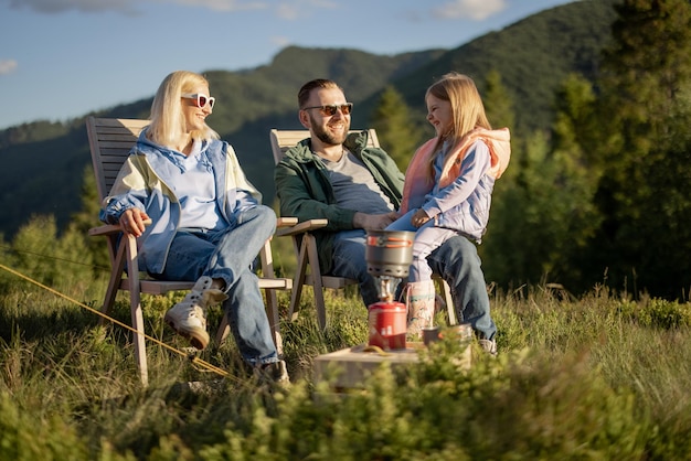 Familia joven con niña en picnic en las montañas