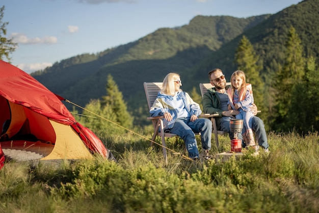 Familia joven con niña en picnic en las montañas