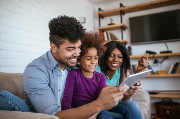 Familia joven con niño divirtiéndose usando tecnología moderna