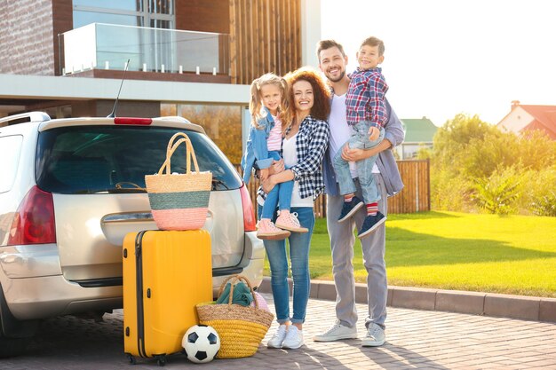 Foto familia joven con niños cerca del coche al aire libre