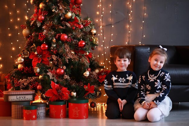 Una familia joven con niños decora la casa para la fiesta de Nochevieja Esperando el nuevo año