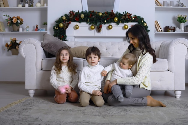 Una familia joven con niños decora la casa para la fiesta de Nochevieja Esperando el nuevo año