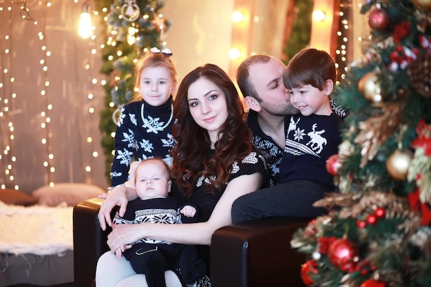 Una familia joven con niños decora la casa para las vacaciones. Vispera de Año Nuevo. Esperando el año nuevo.