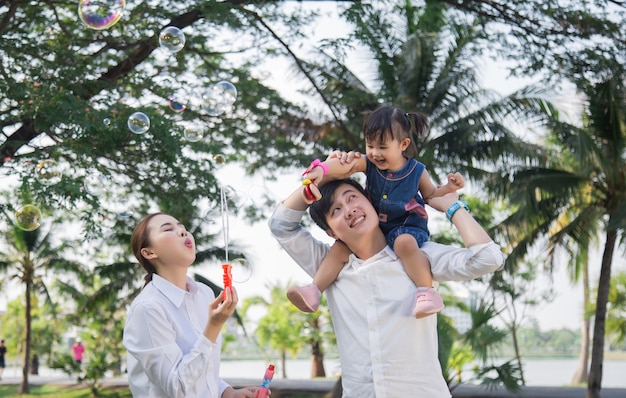 Foto familia joven con niños divirtiéndose afuera