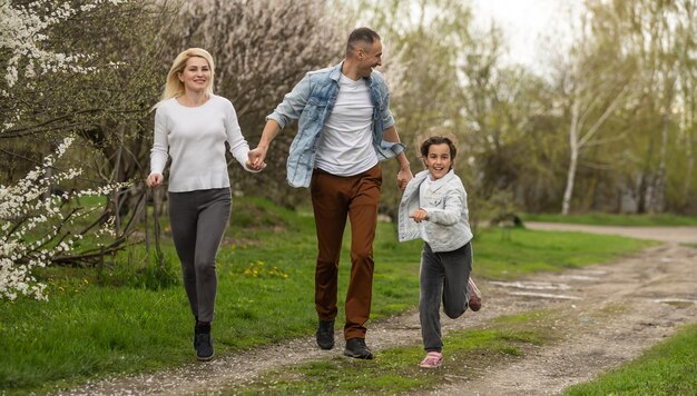 Familia joven con niños y con perro divirtiéndose en la naturaleza