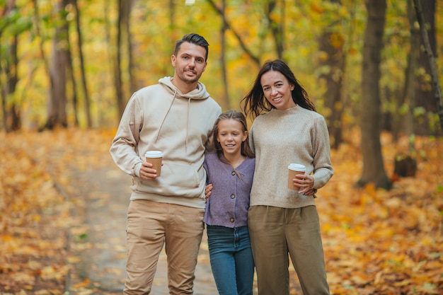 Familia joven en el parque de otoño. Retrato de otoño familiar