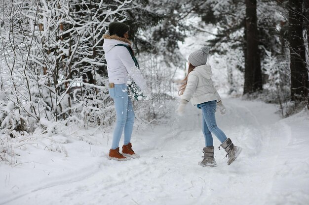 Familia joven a pasear. Mamá e hija están caminando en un parque de invierno.