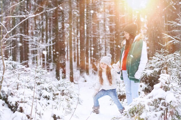 Familia joven a pasear. Mamá e hija están caminando en un parque de invierno.