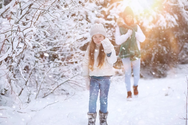 Familia joven a pasear. Mamá e hija están caminando en un parque de invierno.