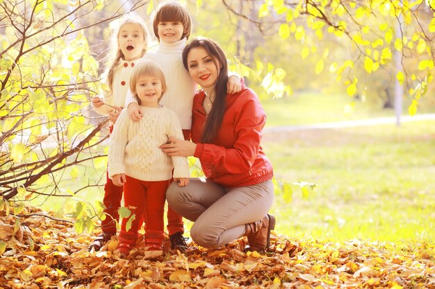 Familia joven en un paseo por el parque de otoño en un día soleado. Felicidad de estar juntos.