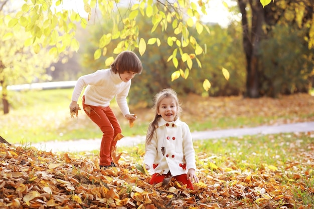 Familia joven en un paseo por el parque de otoño en un día soleado. Felicidad de estar juntos.