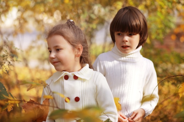 Familia joven en un paseo por el parque de otoño en un día soleado. Felicidad de estar juntos.