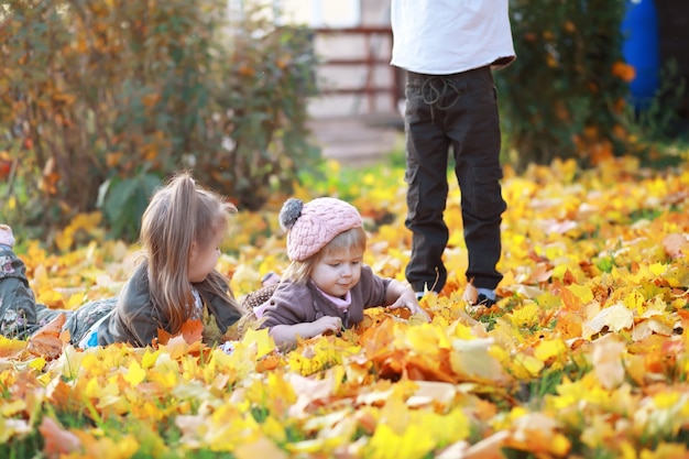 Familia joven en un paseo por el parque de otoño en un día soleado. Felicidad de estar juntos.