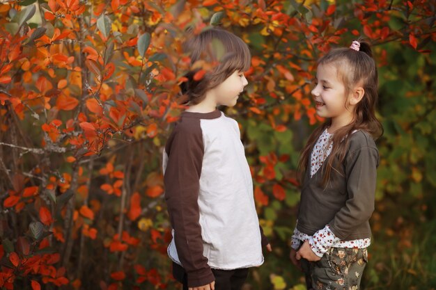 Familia joven en un paseo por el parque de otoño en un día soleado. Felicidad de estar juntos.