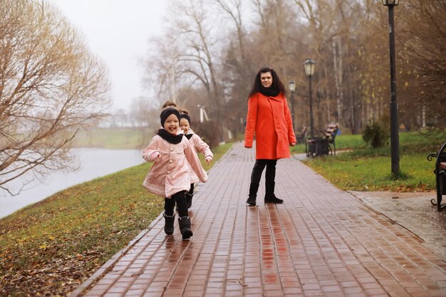 Familia joven en un paseo por el parque de otoño en un día soleado. Felicidad de estar juntos.