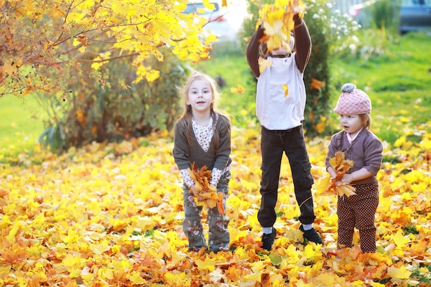 Familia joven en un paseo por el parque de otoño en un día soleado. Felicidad de estar juntos.