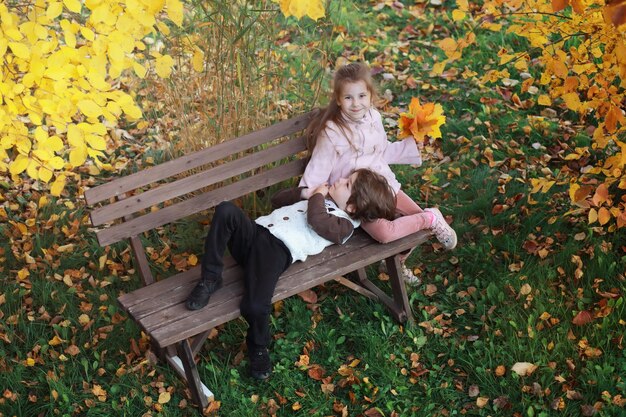 Familia joven en un paseo por el parque de otoño en un día soleado. Felicidad de estar juntos.