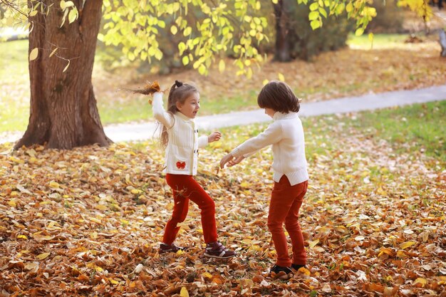 Familia joven en un paseo por el parque de otoño en un día soleado. Felicidad de estar juntos.