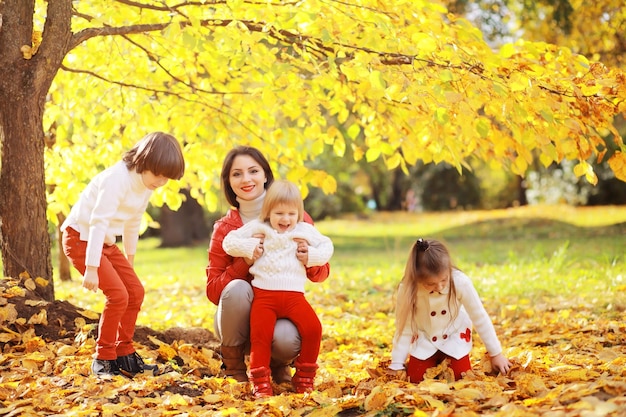 Familia joven en un paseo por el parque de otoño en un día soleado. Felicidad de estar juntos.