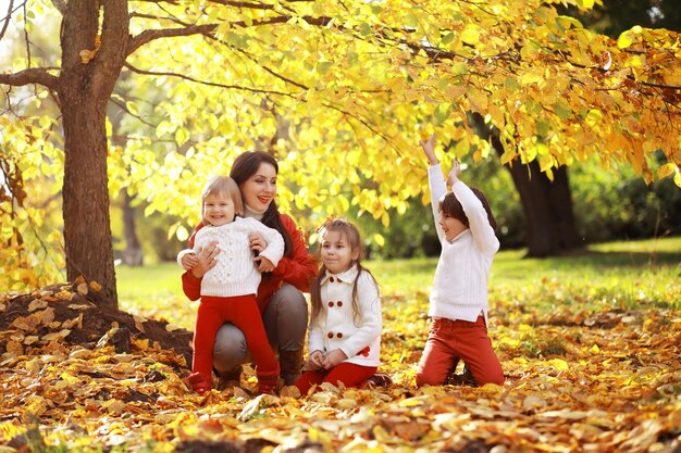 Familia joven en un paseo por el parque de otoño en un día soleado. Felicidad de estar juntos.
