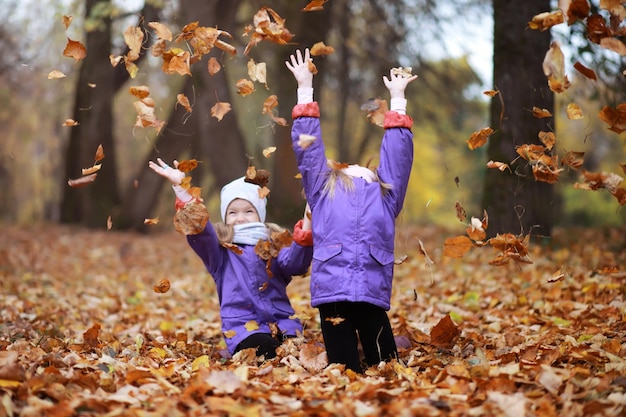 Familia joven en un paseo por el parque de otoño en un día soleado. Felicidad de estar juntos.