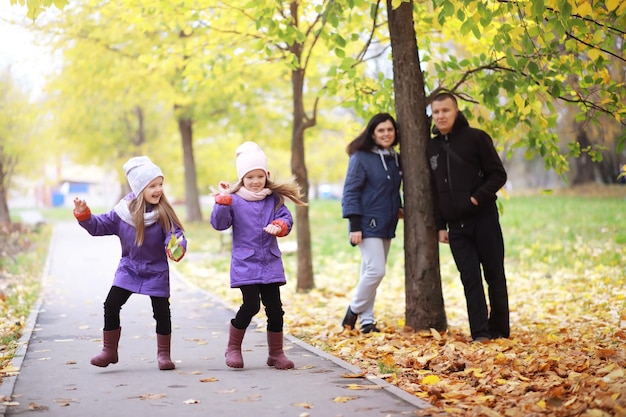 Familia joven en un paseo por el parque de otoño en un día soleado. Felicidad de estar juntos.