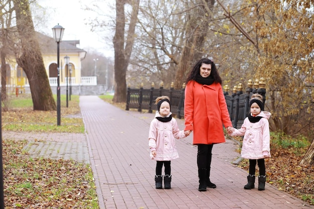 Familia joven en un paseo por el parque de otoño en un día soleado. Felicidad de estar juntos.