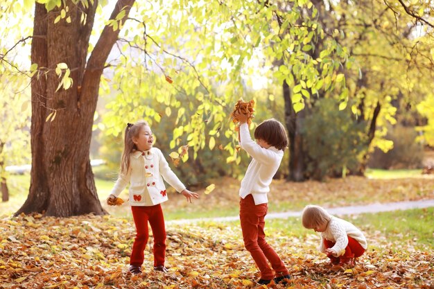 Familia joven en un paseo por el parque de otoño en un día soleado. Felicidad de estar juntos.