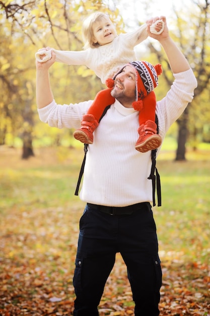 Foto familia joven en un paseo por el parque de otoño en un día soleado felicidad de estar juntos