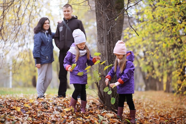Familia joven en un paseo por el parque de otoño en un día soleado Felicidad de estar juntos