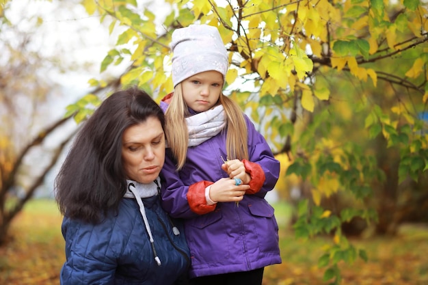 Familia joven en un paseo por el parque de otoño en un día soleado Felicidad de estar juntos