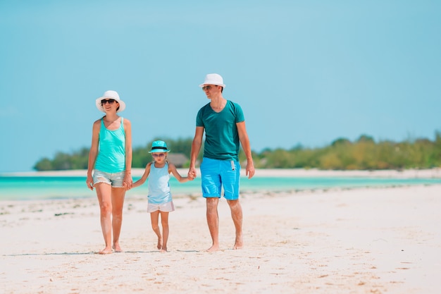 Familia joven en la playa blanca durante las vacaciones de verano